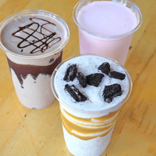 Three Sizzlin City Burger milkshakes: chocolate, strawberry, and cookies and cream with caramel swirls.